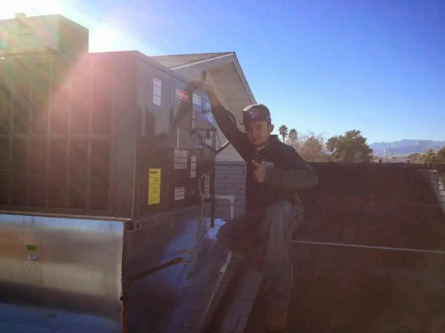 HVAC technician performing HVAC Inspection on a rooftop unit in Central